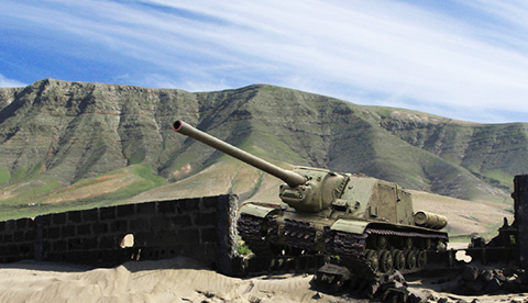 an army tank in a desert landscape poised for action